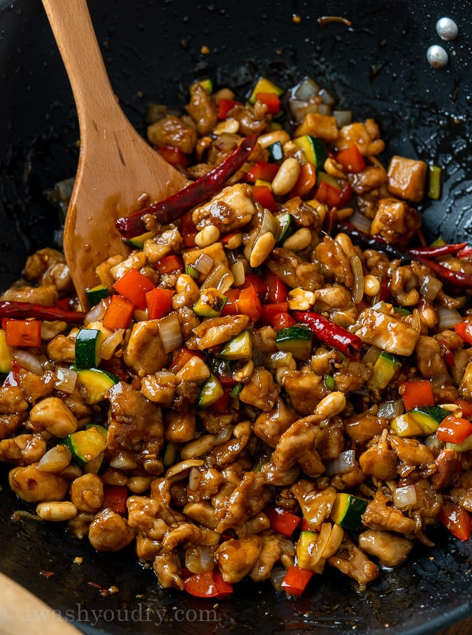 Kung Pao Chicken in wok with vegetables and spoon