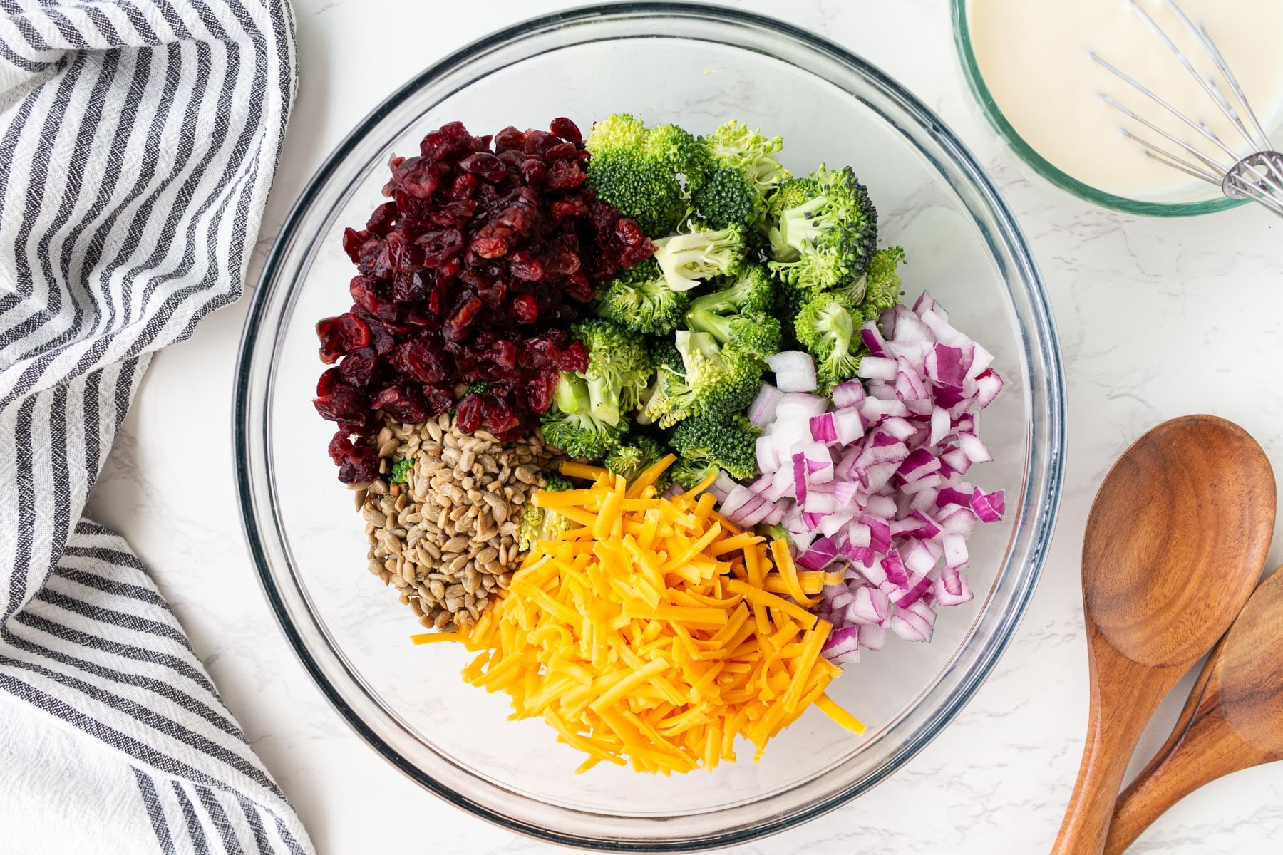 broccoli salad in bowl with dressing on the side.