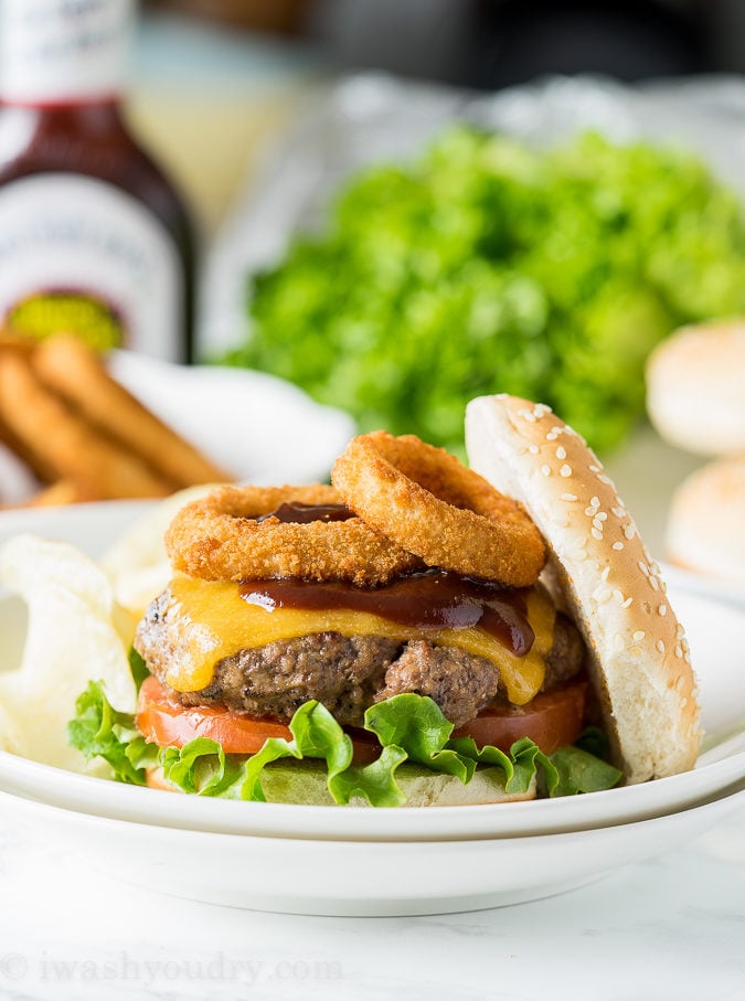 These Honey BBQ Cowboy Burgers are thick and juicy hamburger patties that are topped with cheese, Sweet Baby Ray's Honey BBQ Sauce and crispy onion rings. It's a party in your mouth!