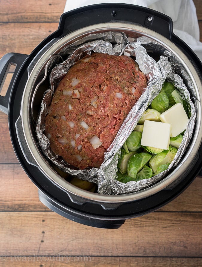 Layer your meatloaf and veggies on top of the potatoes in your Instant Pot and watch the magic happen!