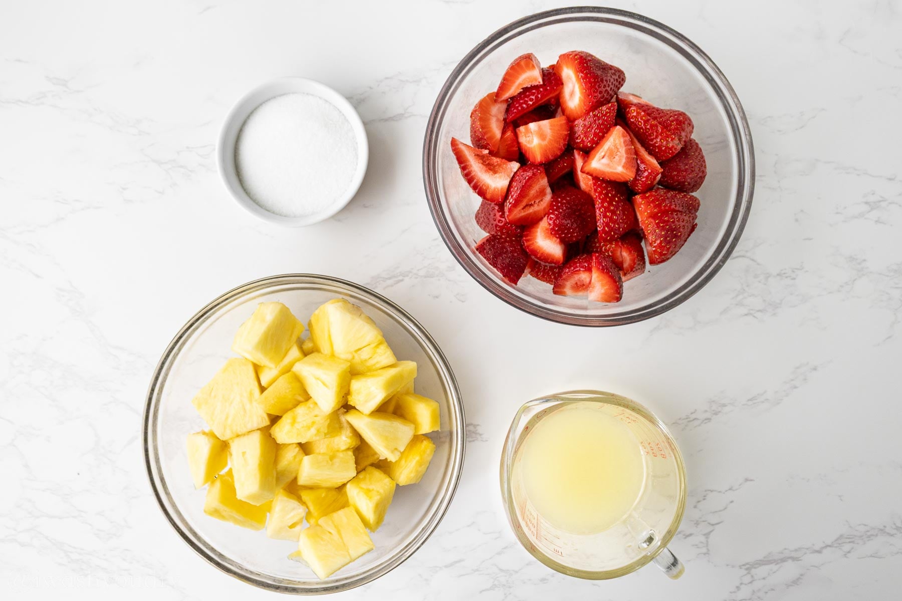 ingredients for strawberry popsicles on white surface.