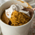 This delightful mug cake is filled with pumpkin spice and topped with whipped cream!