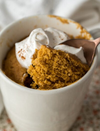 This delightful mug cake is filled with pumpkin spice and topped with whipped cream!
