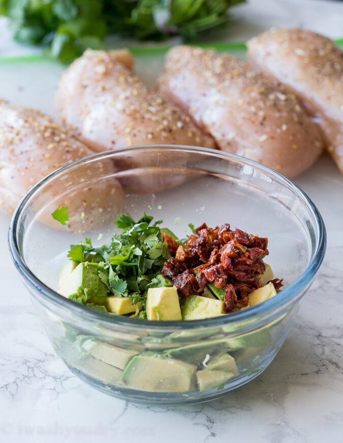 The filling for these super easy chicken breasts is diced avocado, sun dried tomatoes, cilantro and a little bit of salt! So easy and seriously so good!