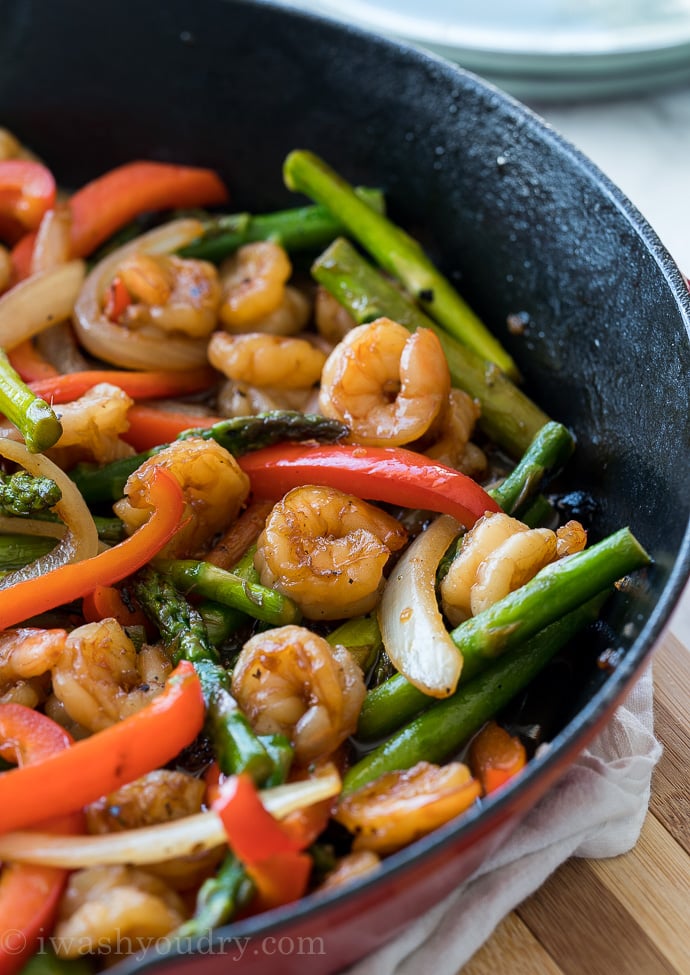 shrimp stir fry in skillet with asparagus and peppers.