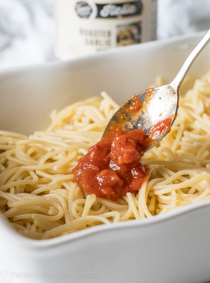 Spoon the sauce over the top of the spaghetti before topping with mozzarella cheese.