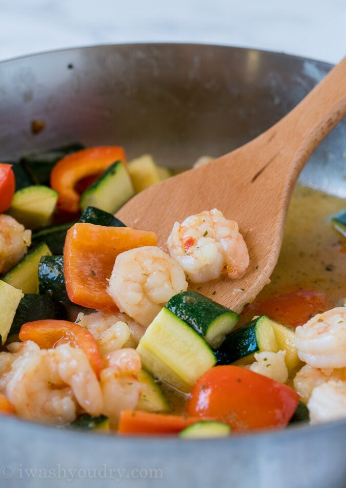 Start by sauteing the zucchini and bell pepper in a little bit of olive oil, then add in the shrimp scampi and cook until the shrimp is cooked through.