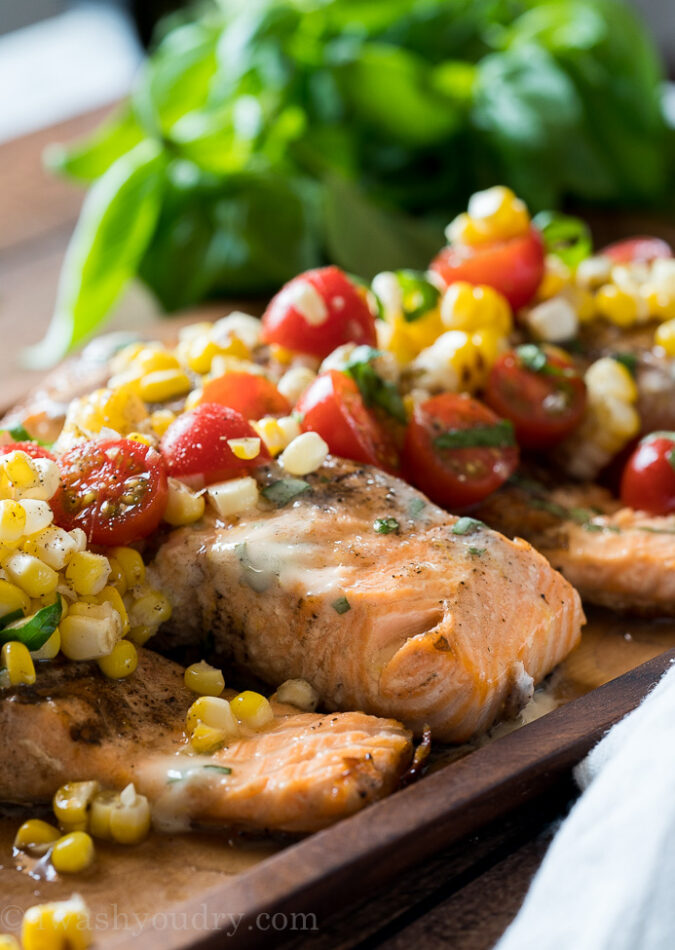 This Lemon Basil Grilled Salmon is topped with a lemon and basil infused butter and a grilled corn and tomato salad that's so fresh and delicious!