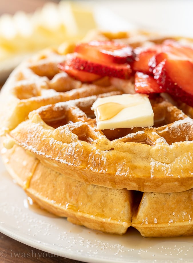 Syrup dripping down side of waffle with butter on top