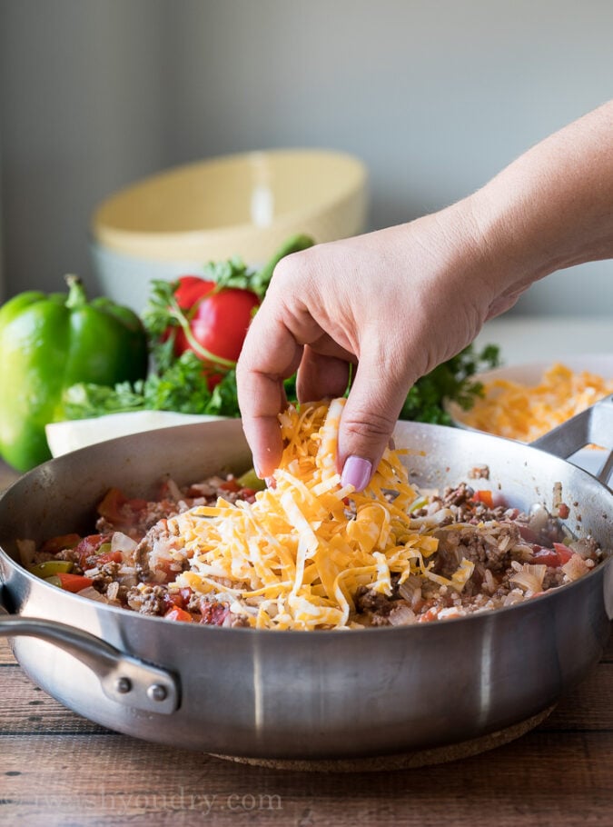 Top the cooked ground beef and rice with some cheese and add the lid back on until the cheese is melted.