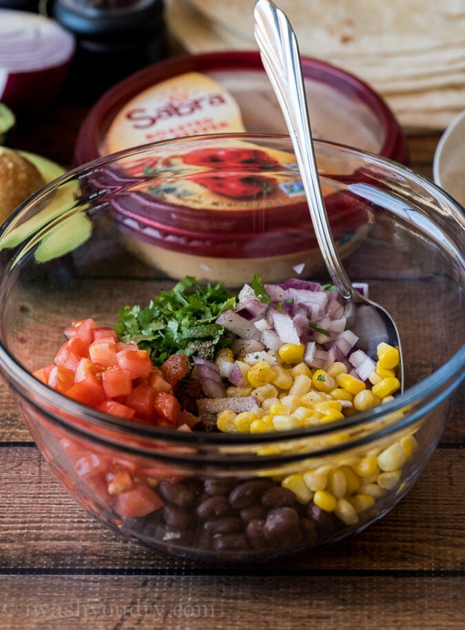 Comience mezclando una salsa de frijoles negros simple que consiste en maíz, frijoles negros, tomate, cebolla y cilantro.