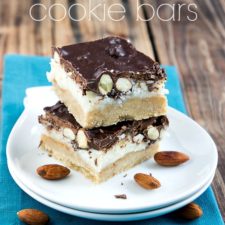 Two Almond Joy Cookie Bars stacked on top of each other on a white plate