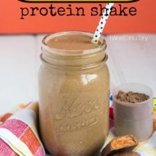 A glass jar of Butterfinger Protein Shake with a polkadot straw