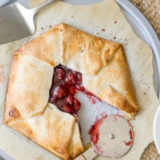 A plate of food with a slice cut out, with cherry pie