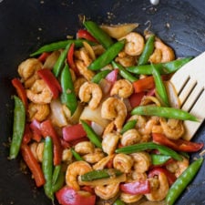 A pan filled with food, with Shrimp, peas and peppers