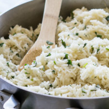 A bowl of rice in a pan with cilantro