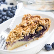 A slice of Blueberry Crumble Cream Pie on a plate