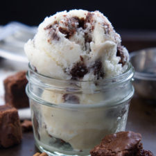 A close up of asmall glass jar with two scoops of Eggnog Brownie Chunk Ice Cream
