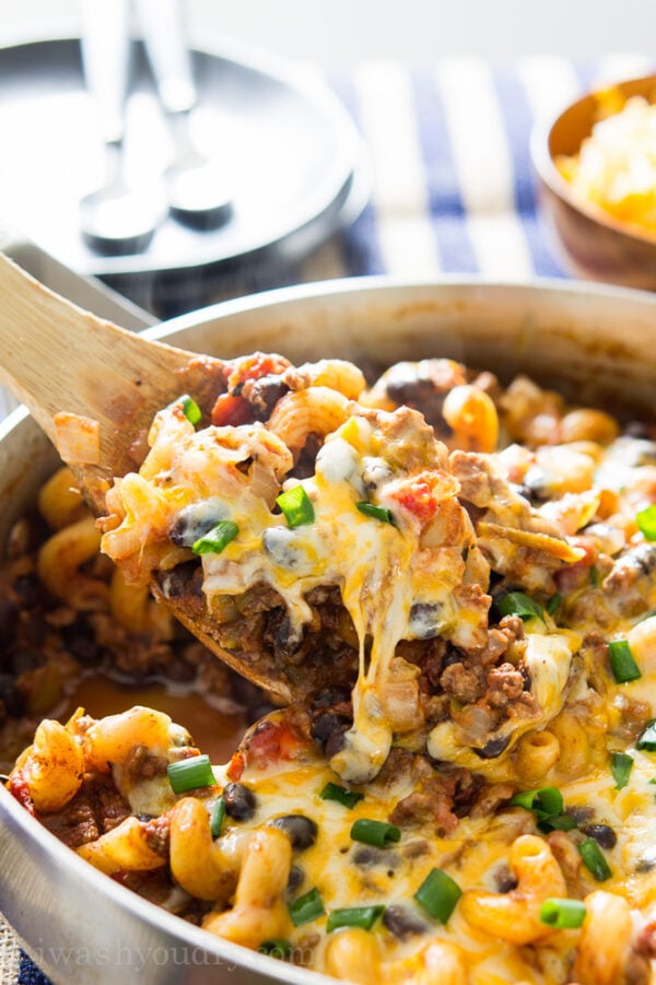 A close up of a spoonful of Chili Pasta over a skillet of food