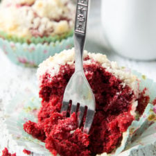 A close up of a red muffin with a fork taking a piece out of it