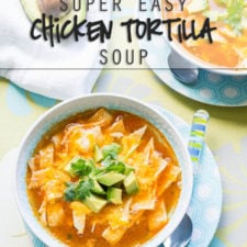A bowl of food on a plate, with chicken tortilla soup topped with avocado