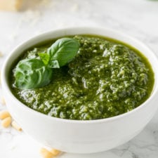 A bowl on a table filled with pesto sauce