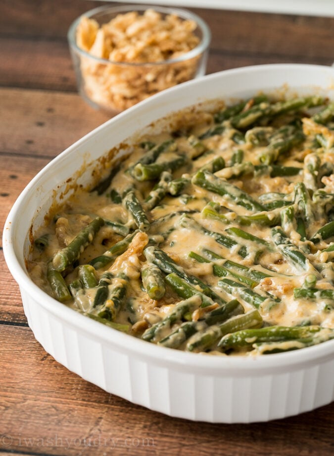 Remove the classic green bean casserole from the oven and stir it up. Top with additional fried onions and pop back into the oven until browned.