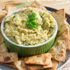 A plate with chips surrounding a bowl of Jalapeño Hummus Dip