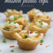 A close up of min Loaded Mashed Potato Cups topped with sour cream and chives