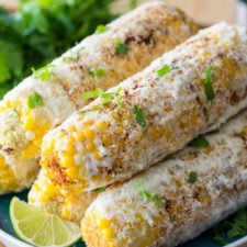 A close up of corn on the cob stacked on a plate