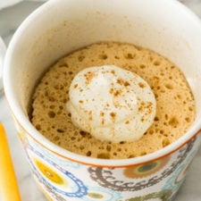 A mug with Cake and topped with whipped cream