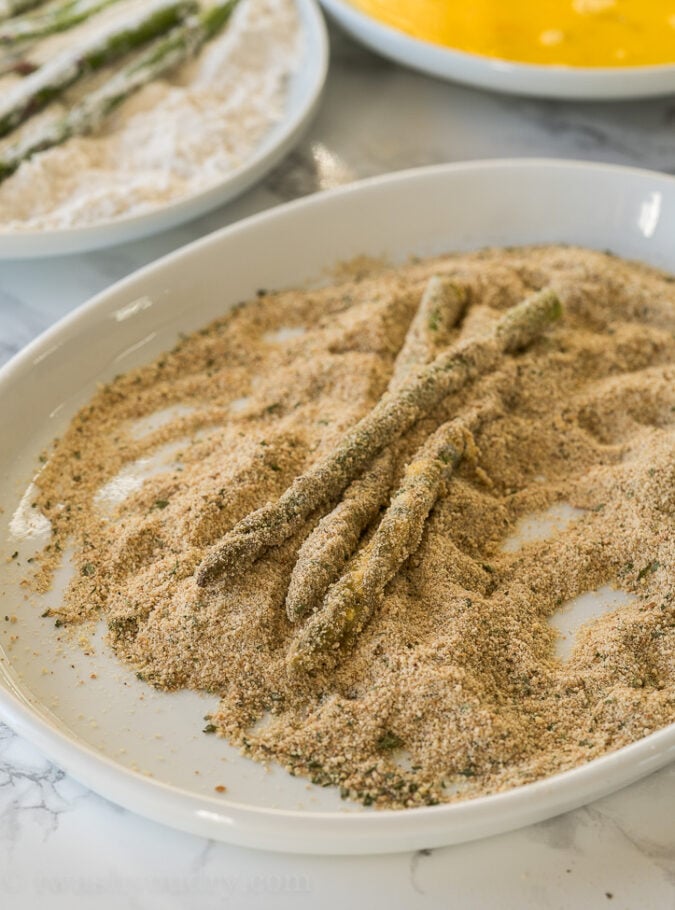 Roll the asparagus spears in flour, eggs and then seasoned breadcrumbs before placing into the air fryer to get nice and crispy.