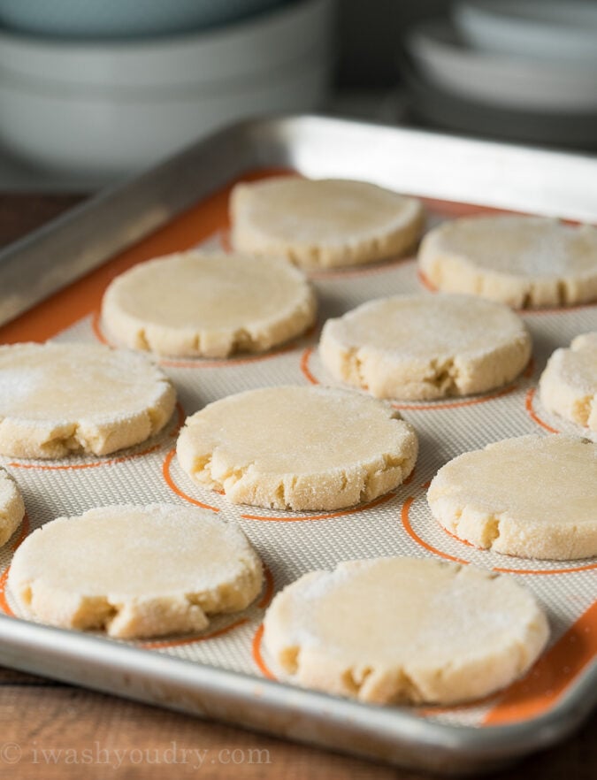 Press each ball of cookie dough into a flat disc and then bake until set. The sugar cookies will not brown, so don't over cook them!
