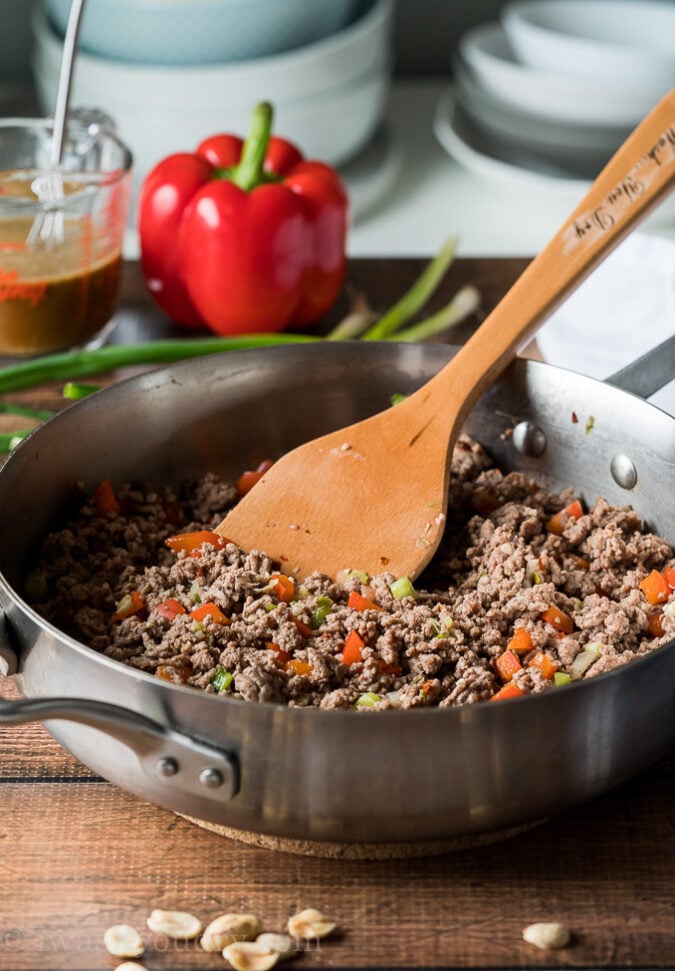 To make this super easy Ground Kung Pao Beef start by browning some hamburger in a skillet with diced bell pepper and onions.