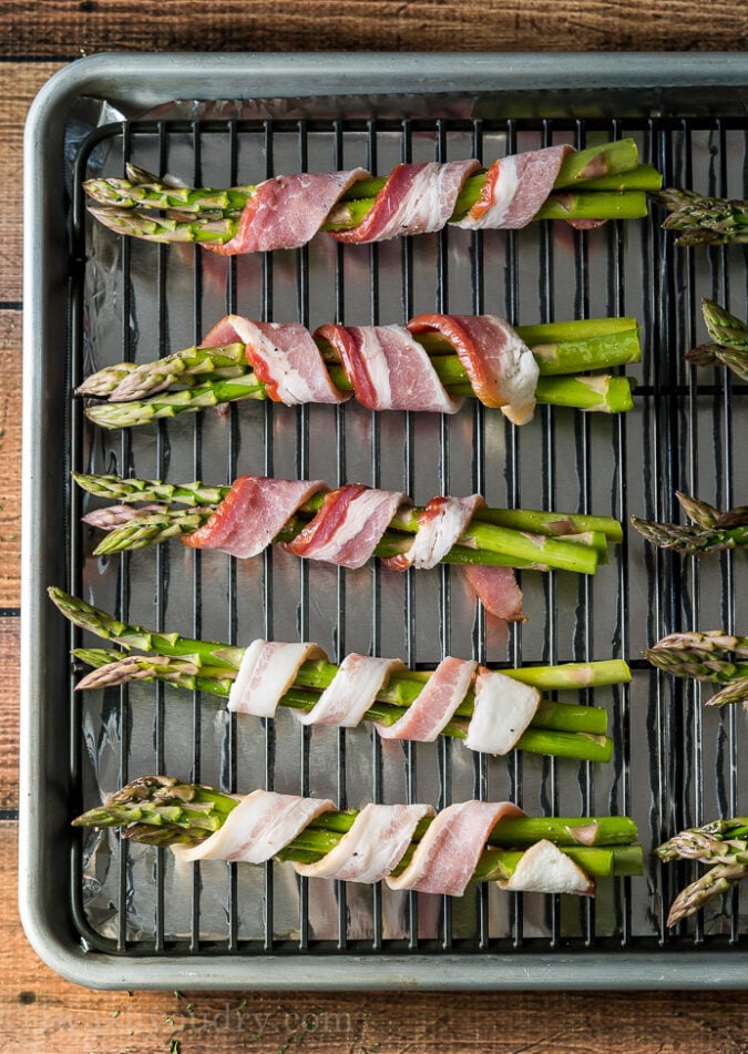 Wrap the asparagus with a skinny strip of bacon and place on a rack in a baking sheet.