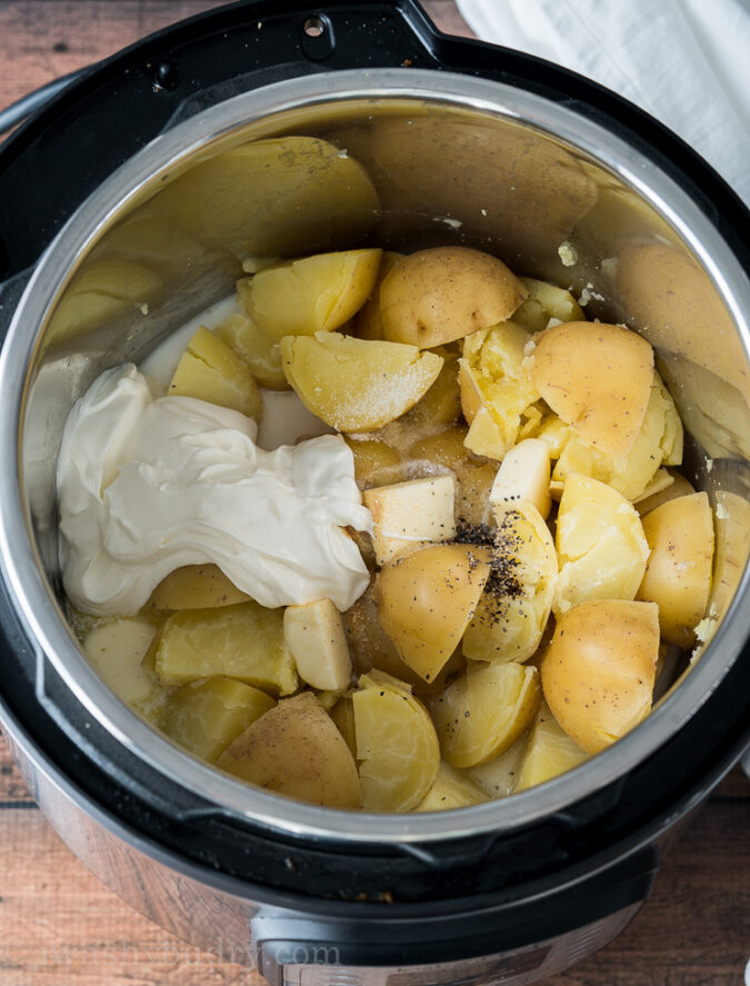 Add in the milk, butter and sour cream to the potatoes and mash.