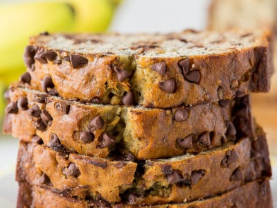 A piece of chocolate cake on a plate, with Banana and Bread