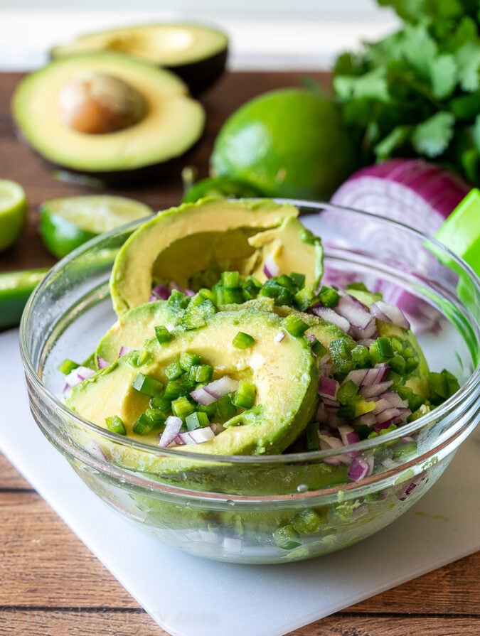 Combine all the ingredients for fresh guacamole into a bowl and use a fork to mash together until you've reached your desired consistency.