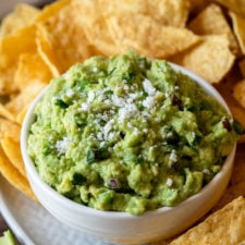 Top your Authentic Guacamole Recipe with fresh cotija cheese and serve with tortilla chips!