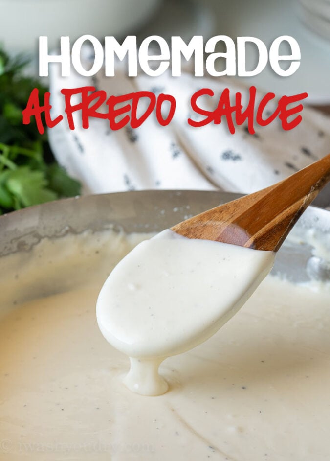 Pot filled with alfredo sauce and spoon dipped in