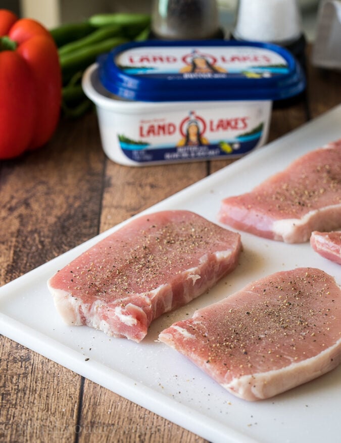 Season the pork chops with salt and pepper before dipping in eggs and a parmesan coating.