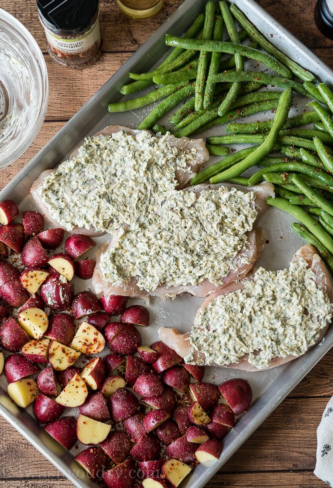 Spread the cheesy spinach herb mix over the top of the chicken breasts and bake the sheet pan meal until the chicken is cooked through.