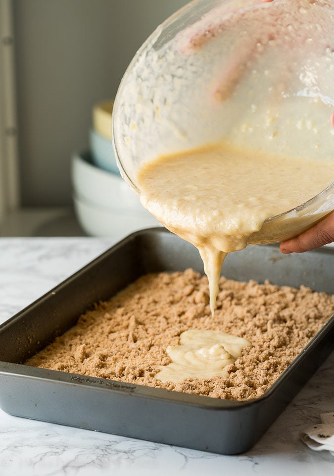 Pour the banana cake batter over the crumb topping layer.