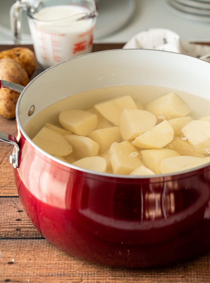 Pour warm milk and melted butter into the cooked potatoes