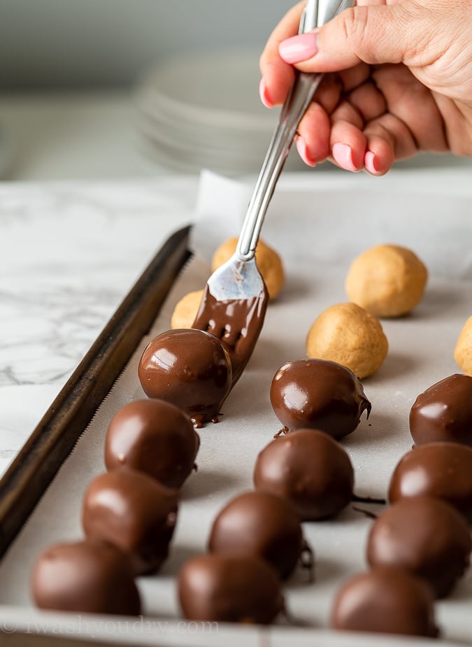 Dip the peanut butter balls in chocolate and place on a parchment lined baking sheet.
