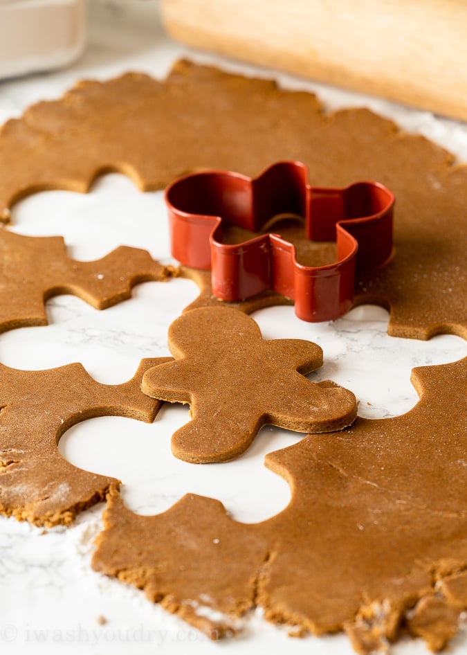 Roll out chilled gingerbread cookie dough and use cookie cutters to cut into shapes.