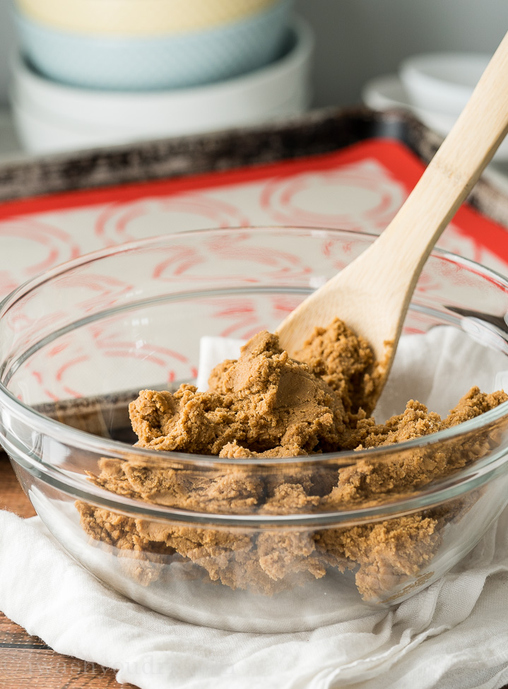 bowl of gingerbread cookie dough with wooden spoon.