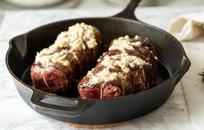 Slather the seared beef tenderloin in garlic butter and finish cooking in the oven