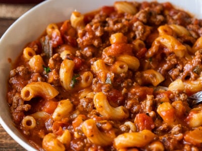 Tender macaroni pasta in a beef and tomato sauce in a white bowl.