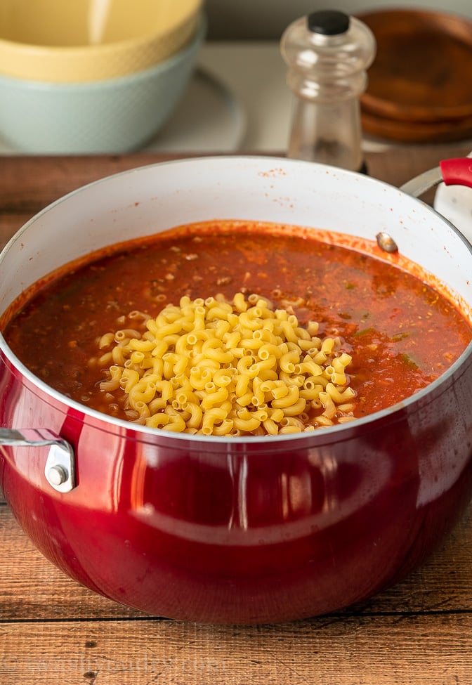 Dry macaroni noodles in a pot of Goulash